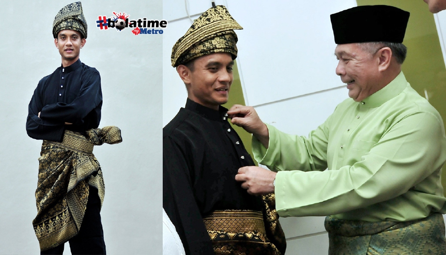 Dr Abdul Latiff (kanan) memperkemaskan pakaian tradisional Melayu Mohd Faiz. FOTO BERNAMA 