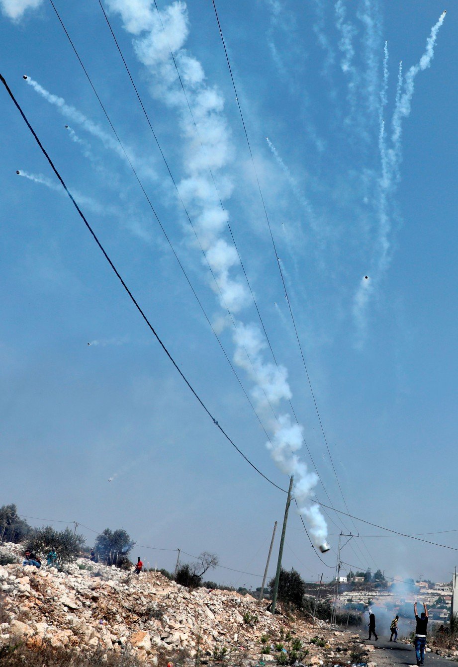 TENTERA Israel menembak gas pemedih mata ke arah rakyat Palestin yang mengadakan demonstrasi di sebuah kawasan perkampungan di Tebing Barat pada 11 September. FOTO AFP 