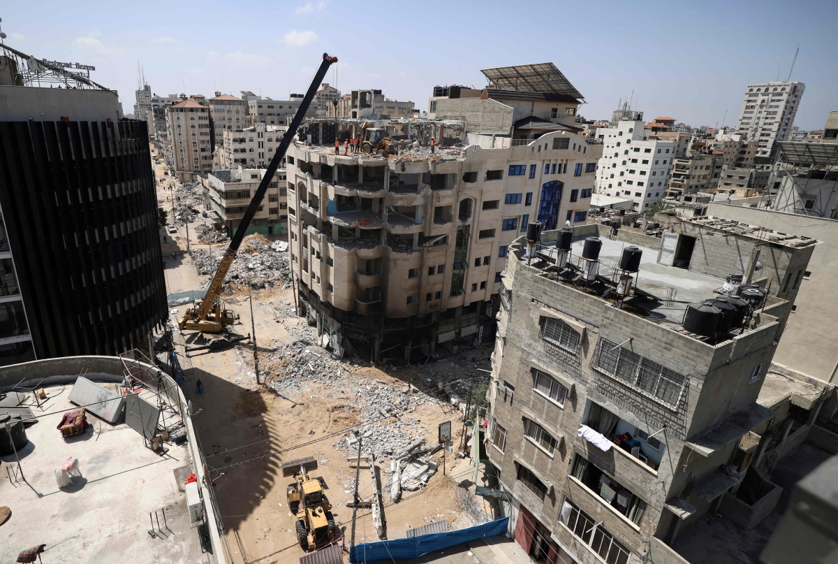 ANGGOTA pembinaan membaiki semula bangunan yang rosak. FOTO AFP