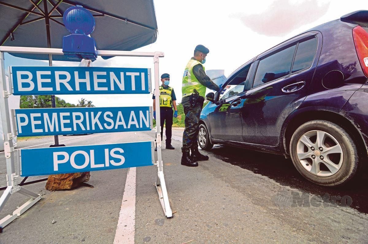 ANGGOTA polis bertugas di sekatan jalan raya (SJR) di Jalan Papar-Penampang bagi membendung penularan Covid-19. FOTO Mohd Adam Arinin.