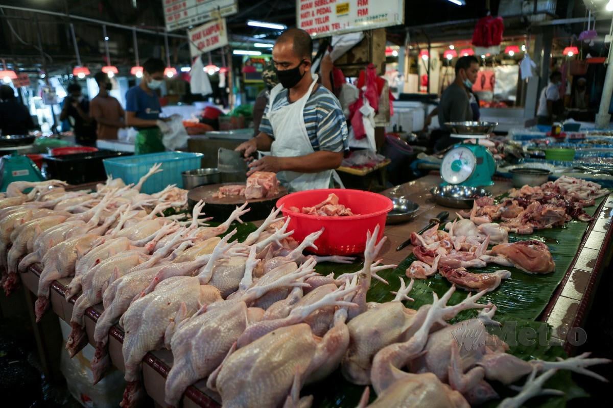 Peniaga memotong ayam tempahan pelanggan di Pasar Keramat semalam. Foto Asyraf Hamzah