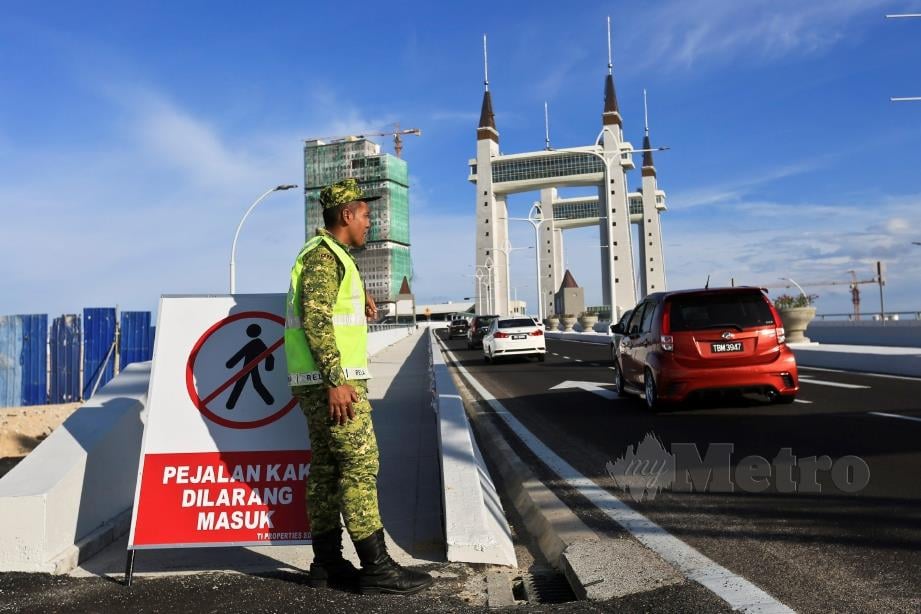 ANGGOTA RELA memantau kenderaan yang melalui Jambatan Angkat (Drawbridge) yang menghubungkan antara Kuala Terengganu dan Kuala Nerus selepas ia dibuka mulai Ahad lalu hingga 17 Jun ini. FOTO Ghazali Kori.
