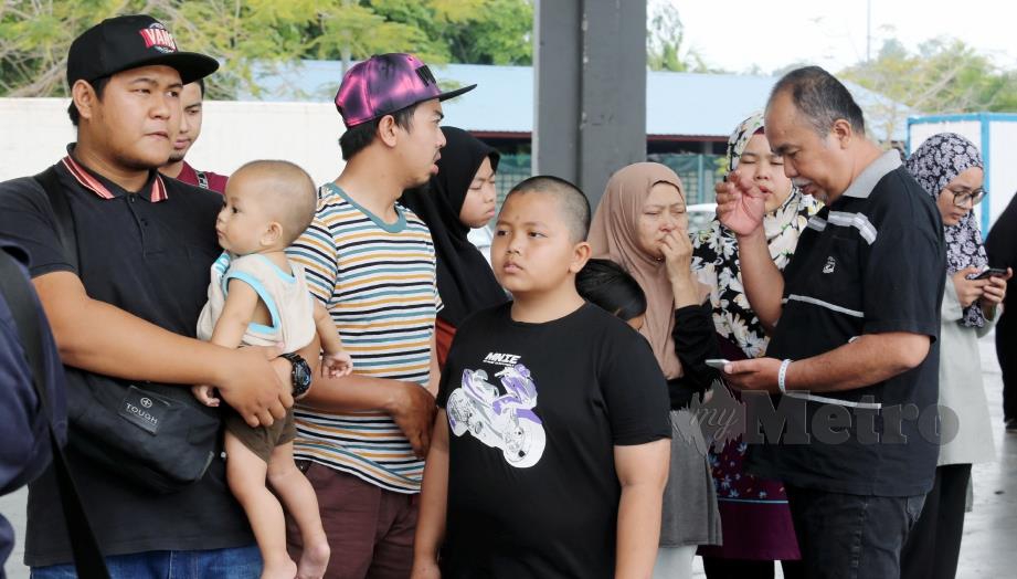 AIDZUHAN (kanan) serta Salmah (dua dari kanan) bersama keluarga selepas dimaklumkan jenazah Mohd Afizudin ditemui pada 12.45 tengah hari di Jeti LKIM, Kuala Linggi, dekat Alor Gajah. FOTO Rasul Azli Samad.