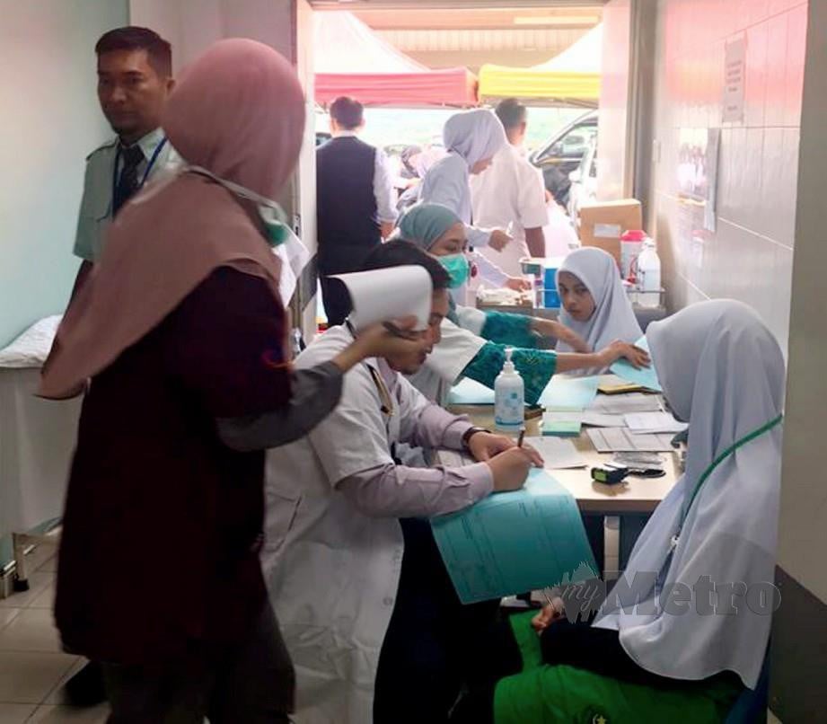 Pelajar lelaki dan perempuan SMAKJ diberikan rawatan kecemasan di HEBHK Kluang. FOTO Ihsan pembaca