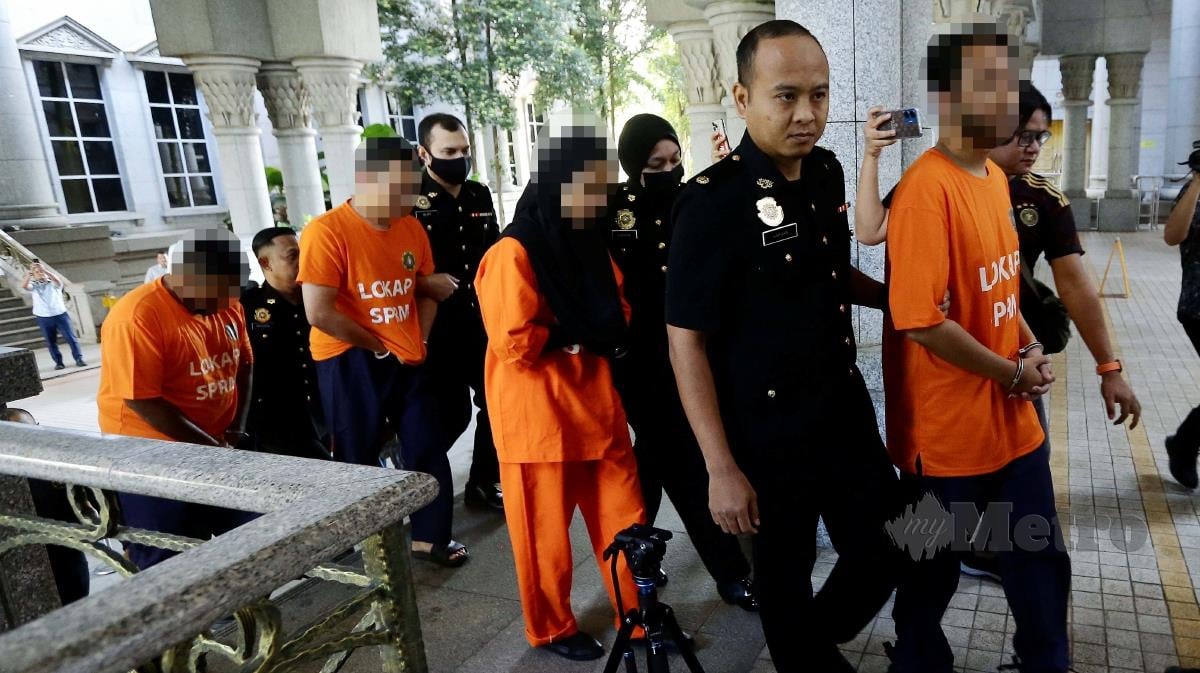 Pegawai SPRM membawa pasangan suami isteri yang juga pempengaruh yang terpalit dengan isu dakwaan menyeleweng kutipan derma untuk direman di Mahkamah Majistret Putrajaya. FOTO MOHD FADLI HAMZAH