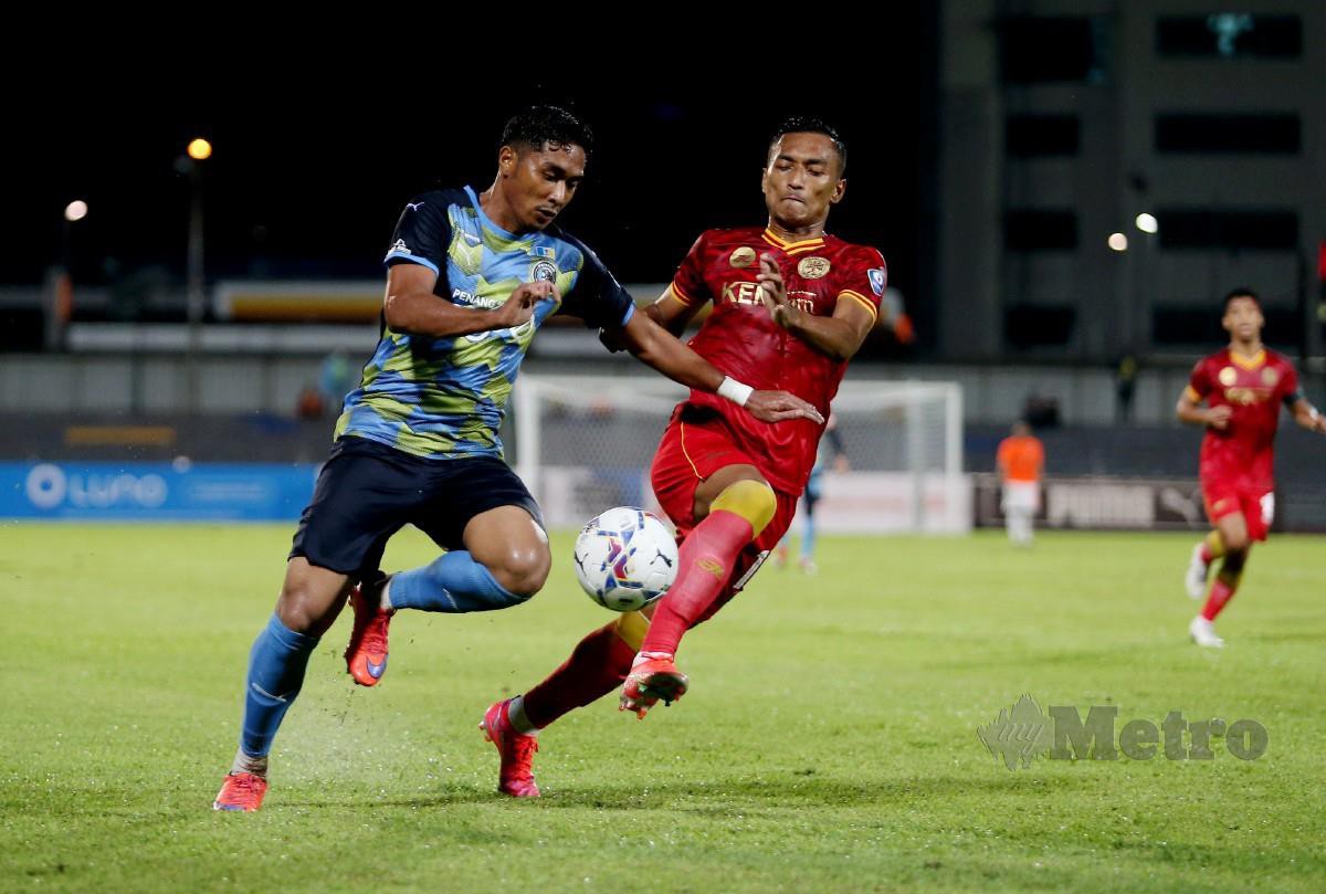 Pemain Penang FC, Mohammad Khairul Akmal Rokisham (kiri) mengawal bola ketika perlawanan Liga Super menentang Melaka United FC di Stadium Bandaraya Pulau Pinang. FOTO Mikail Ong