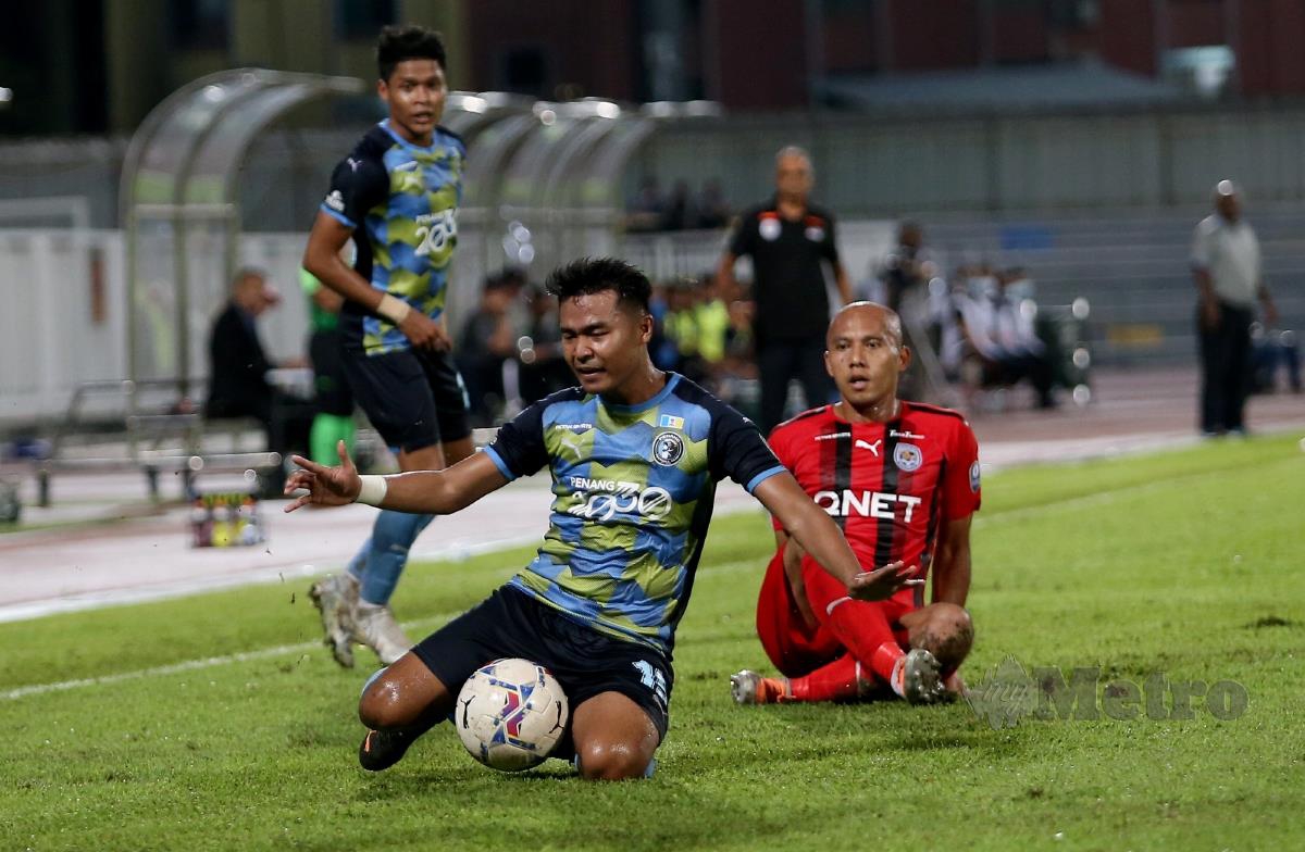 PEMAIN Penang FC, Mohammad Fairuz Zakaria diasak pemain PJ City, Mahalli Jasuli. FOTO Mikail Ong
