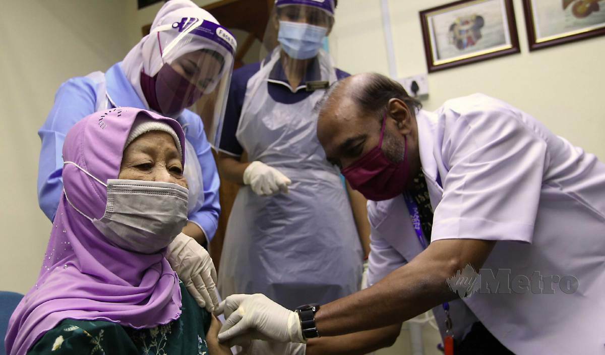 DR K Supramaniam (kanan) melakukan suntikan vaksin jenis Sinovac kepada penerima vaksin, Salbiah yang hadir di Klinik Perak Medical Centre Sdn Bhd, Jalan Tun Sambanthan. FOTO Sharul Hafiz Zam