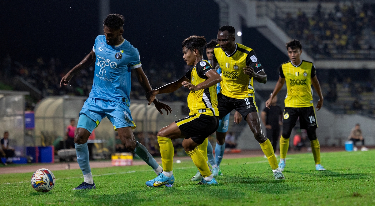 PEMAIN Penang FC Syamer Kutty (kiri) mengawal bola ketika bertemu  Perak FC  di Stadium Perak. FOTO Bernama