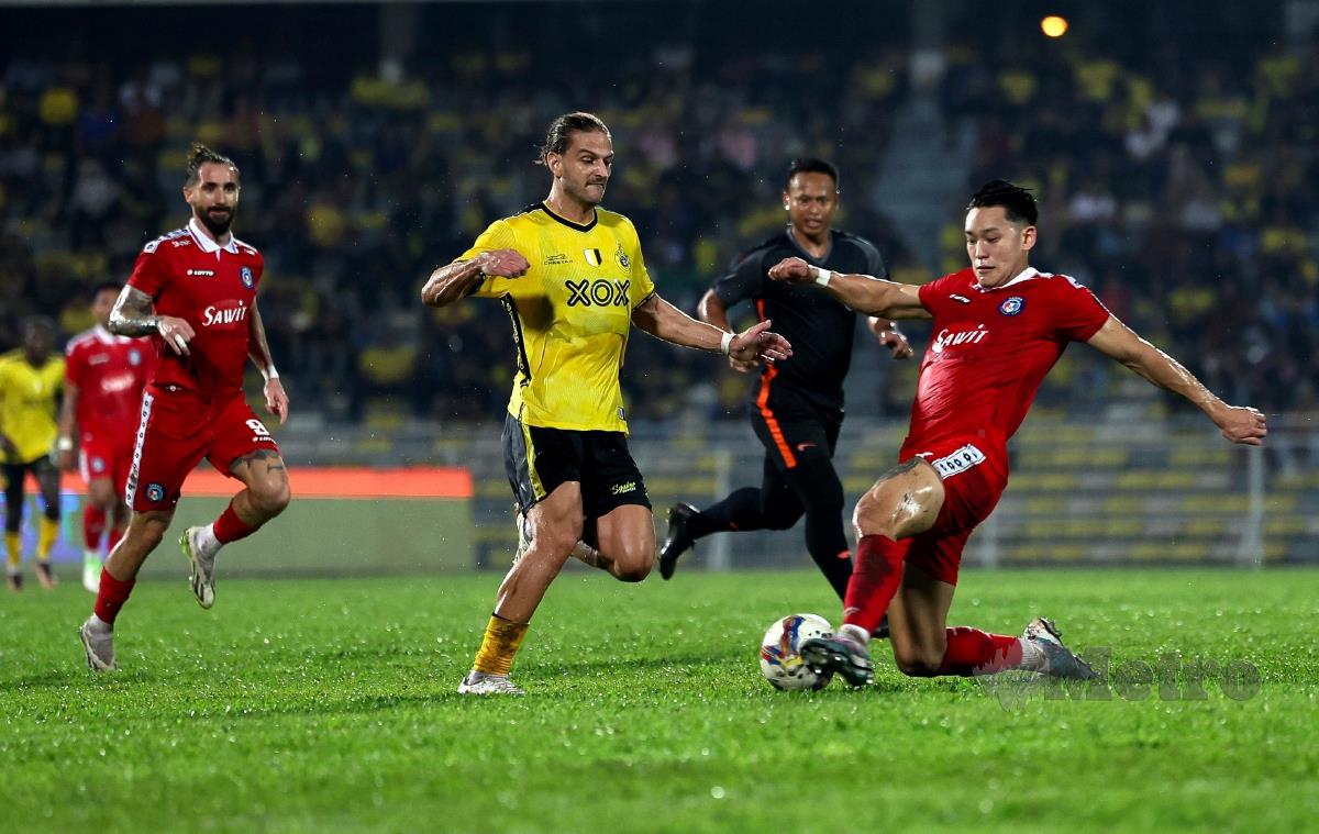 PEMAIN Perak FC, Luka Milunovic (tengah) berebut bola dengan pertahanan Sabah, Dominic Tan pada perlawanan di Stadium Perak, Ipoh, malam tadi. FOTO BERNAMA 