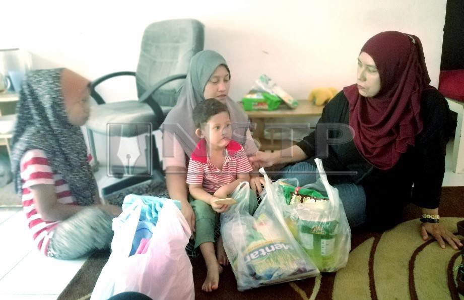 PRESIDEN PERKASIH N9, Norfadilah Mansor (kanan) menyampaikan bantuan barangan makanan kepada ibu tunggal, Suraya Ahmad, 36, di rumahnya di Mantin, Seremban. FOTO Mohd Khidir Zakaria 