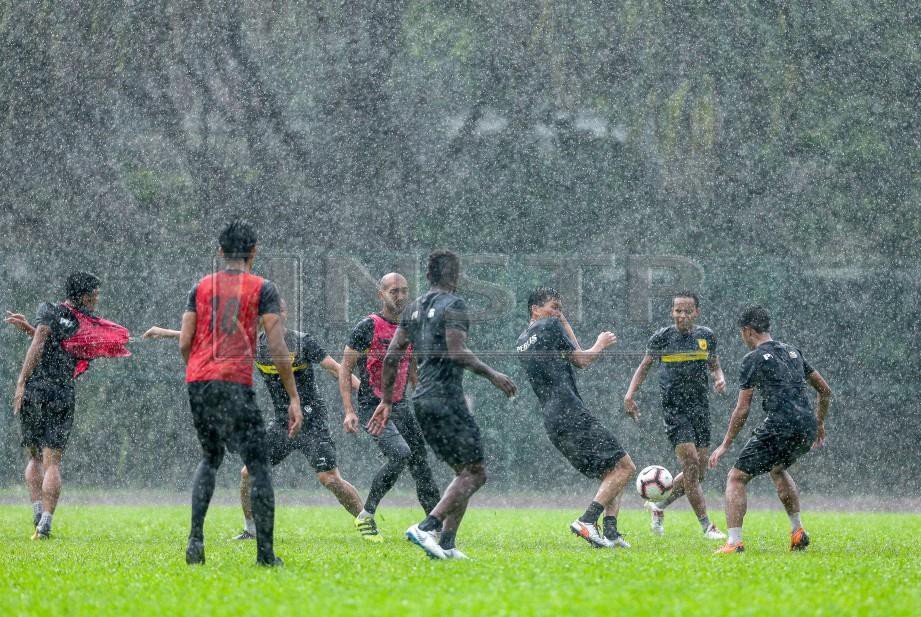 PEMAIN Perlis berlatih dalam keadaan hujan ketika sesi latihan pasukan Perlis di padang Arena Universiti Malaya. -Foto Luqman Hakim Zubir