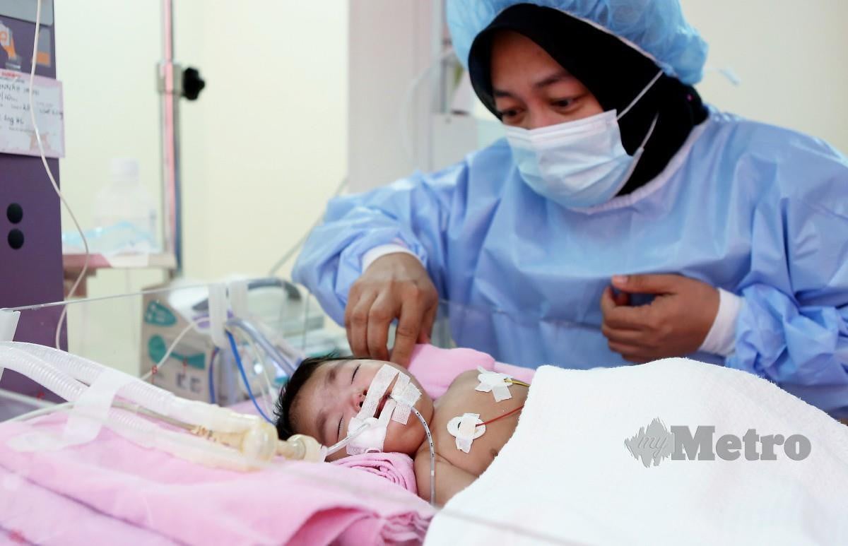 Wan Norzieyana melihat keadaan bayinya, Nurjannah yang perlu menjalani pembedahan segera. FOTO Amirudin Sahib 