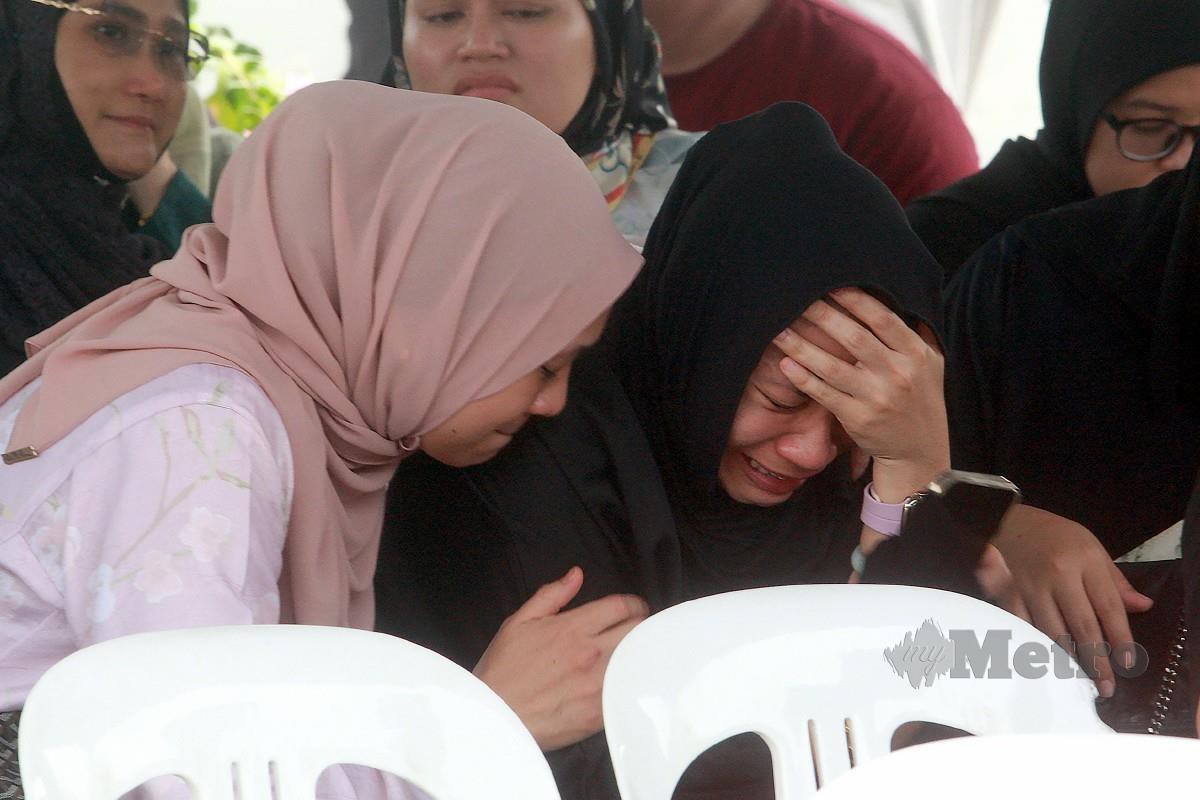 AHLI keluarga mangsa tidak dapat menahan sebak ketika menunggu di perkarangan Jabatan Forensik Hospital Tengku Ampuan Rahimah. FOTO Faiz Anuar