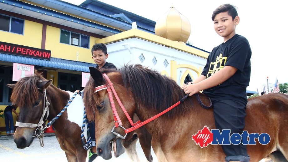PELAJAR Mohd Ghaffar Mohd Paud, 11, (kanan) bersama rakannya ketika menyertai Kembara Amal Berkuda ke sembilan masjid. FOTO Amir Irsyad Omar
