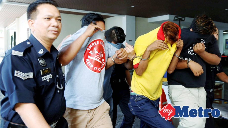 ANGGOTA polis mengiringi empat lelaki berhubung kes baling batu ke arah bas penyokong bola sepak Kedah. FOTO Ramdzan Masiam