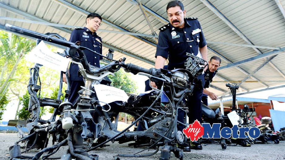 ANUAR (kanan) menunjukkan rangka motosikal  yang dicuri. FOTO Mikail Ong