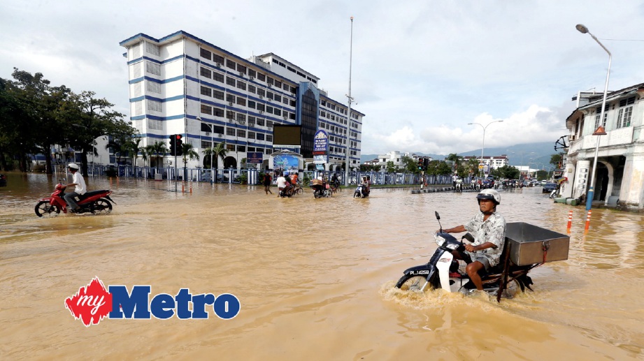 PERSIMPANGAN Jalan Patani, Jalan Datuk Kramat dan Jalan Siam berhadapan Ibu Pejabat Polis Daerah Timur Laut yang ditenggelami air selepas hujan lebat. FOTO Ramdzan Masiam