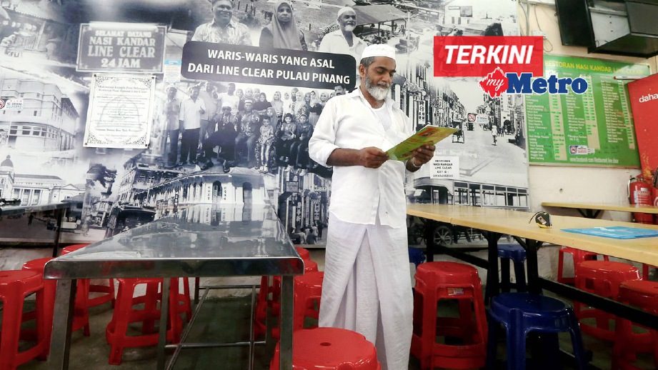SAHUBAR membaca notis kebenaran membuka semula premis oleh Kementerian Kesihatan di Restoran Nasi Kandar Line Clear, Jalan Penang. FOTO Danial Saad