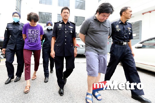 ANGGOTA polis membawa dua beranak yang didakwa membunuh tanpa niat warga emas. FOTO Mikail Ong
