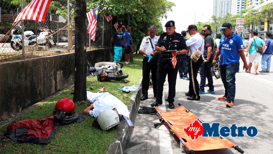 PEGAWAI polis memeriksa mayat mangsa di tempat kemalangan. FOTO Mikail Ong