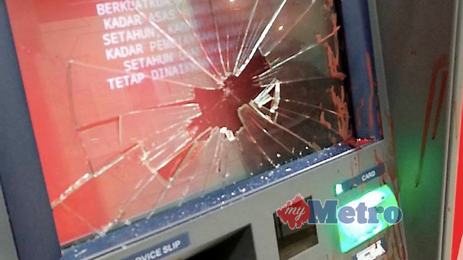 SKRIN mesin ATM pecah ditumbuk seorang lelaki. FOTO ihsan pembaca