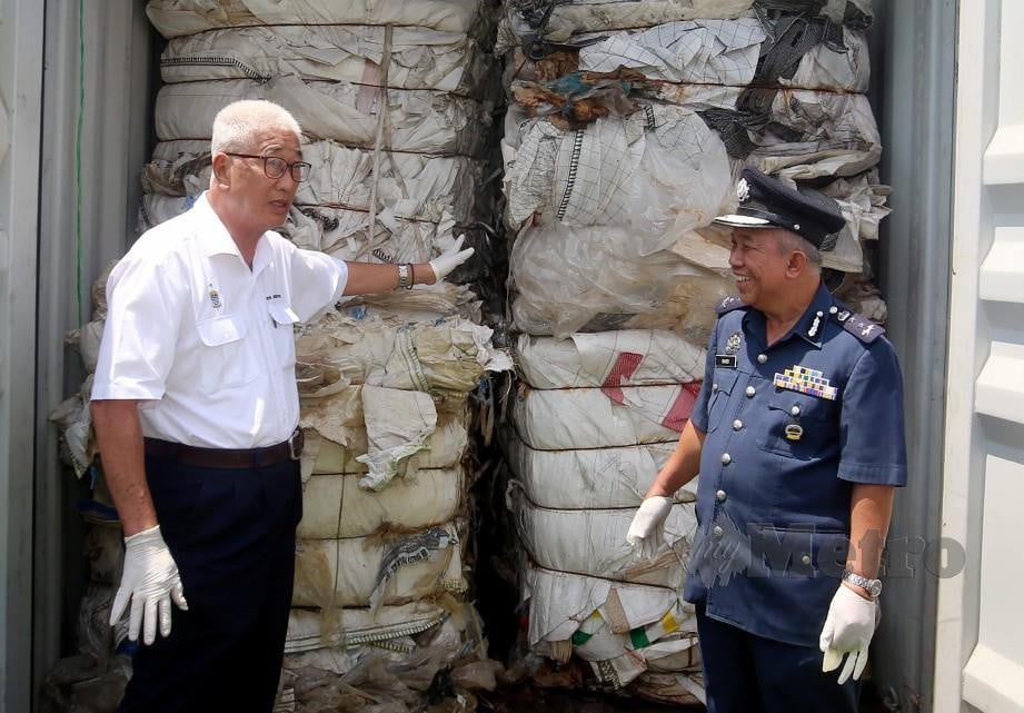 BOON Poh (kiri) bersama Saidi menunjukkan kontena yang mengandungi sisa plastik. FOTO Danial Saad