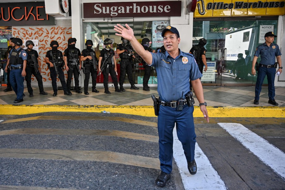 POLIS mengawal kawasan di salah satu pintu masuk pusat beli-belah berkenaan. FOTO AFP 