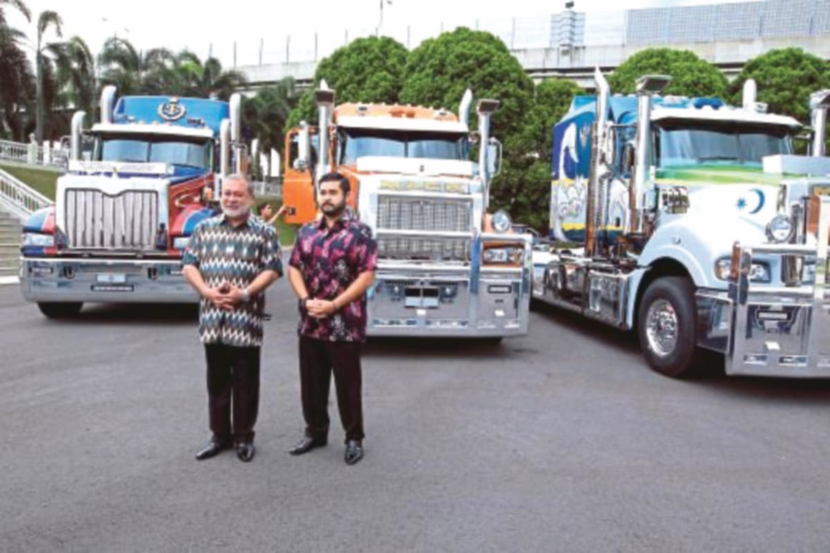 SULTAN Ibrahim Iskandar bersama Tunku Mahkota Johor, Tunku Ismail bergambar kenangan dengan tiga Trak Mack yang dimiliki.