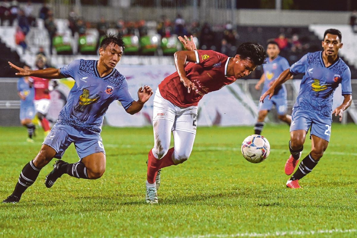 PEMAIN  Kelantan United FC, Mohd Faisal Mohd Rosli (kanan) mengasak pemain Kinabalu Jaguar FC,  Muhammad Zaki Sapri  di Stadium Sultan Ismail Nasiruddin Shah. FOTO Bernama  