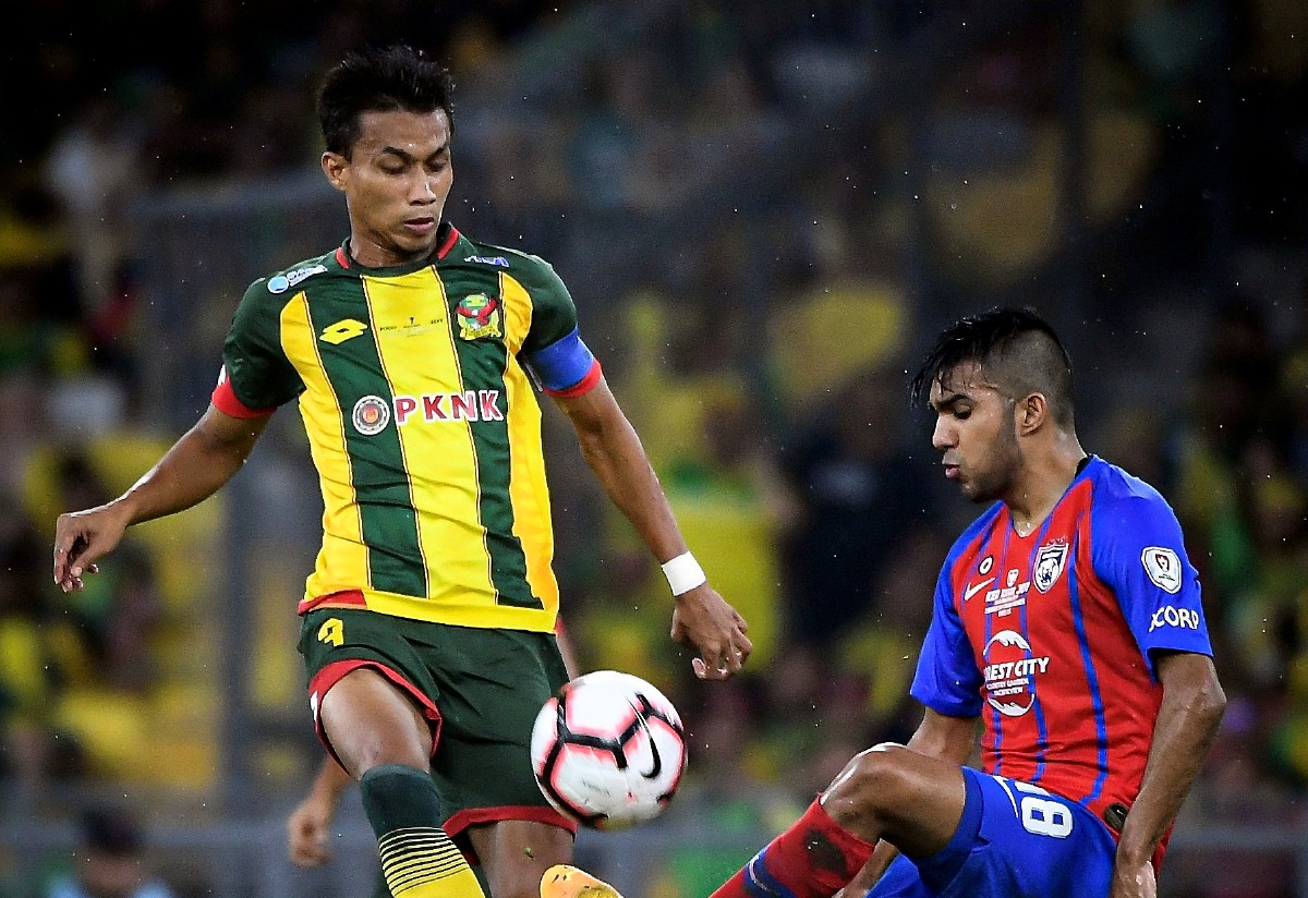 Pemain KDA FC, Baddrol Bakhtiar (kiri) mengasak pemain Johor Darul Ta’zim dalam saingan Liga M.