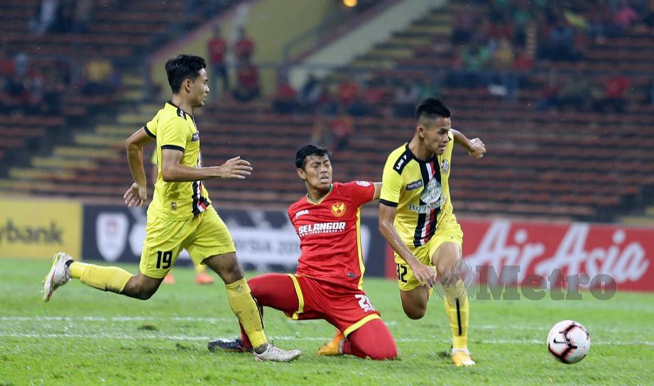 Pemain Selangor, Muhammad Syahmi Safari diasak dua pemain PDRM pada aksi Piala Malaysia di Stadium Shah Alam. FOTO Roslin Mat Tahir