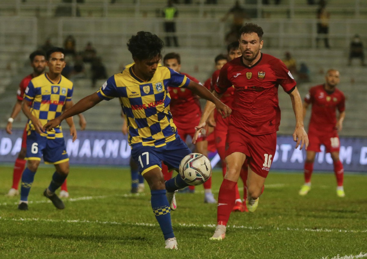 Pemain Sri Pahang, Muhammad Zuhair Aizat diasak pemain Sarawak United, Stuart Wilson (kanan) pada aksi Piala Malaysia. FOTO Farizul Hafiz Awang