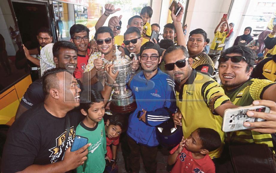HASNUL (pegang piala) bergambar dengan Piala Malaysia dan penyokong Perak ketika tiba di Stadium Perak, Ipoh. FOTO/MUHAIZAN YAHYA