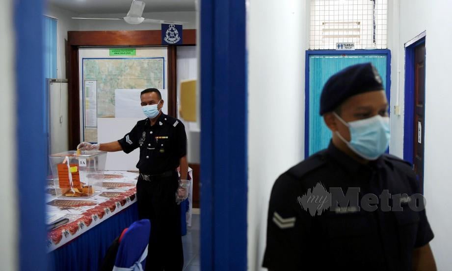 ANGGOTA polis memasukkan kertas undi dalam peti ketika mengundi awal bagi PRK DUN Chini di Balai Polis Chini hari ini. FOTO Bernama