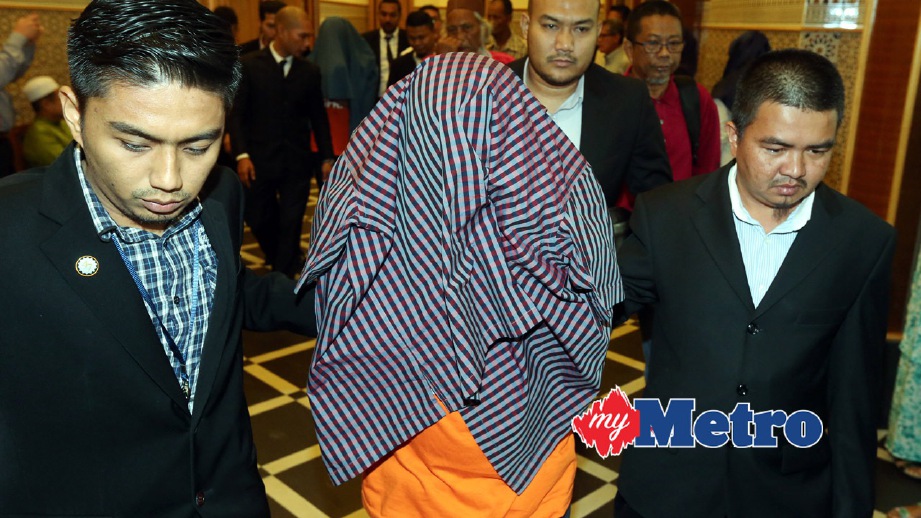 KSU (depan) bersama seorang anaknya dibawa keluar dari Mahkamah Majistret Putrajaya. FOTO Mohd Fadli Hamzah