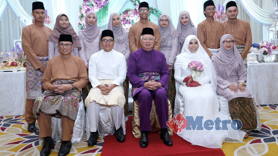 NAJIB (duduk, tengah) menghadiri majlis pernikahan anak Mohd Puad, Nur Hanini (dua kanan) dan Mohamad Azim (dua kiri). FOTO Ahmad Irhmah Mohd Noor