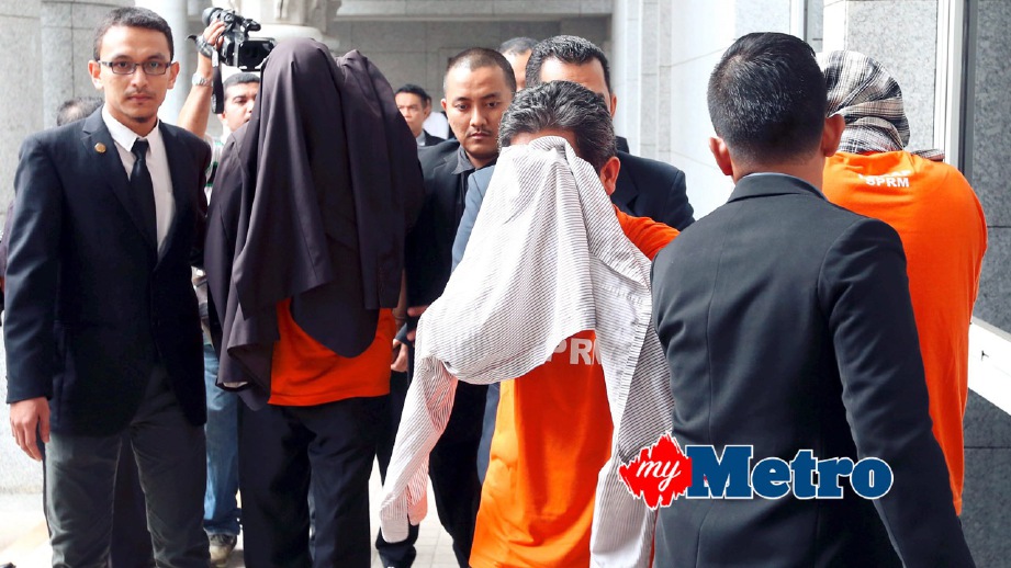 PEGAWAI SPRM membawa suspek untuk memohon perintah tahanan reman di Mahkamah Majistret Putrajaya. FOTO Fariz Iswadi Ismail