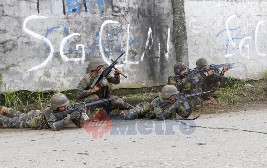 Tentera Filipina mengambil kedudukan ketika bertempur dengan mlitan Maute di Marawi, Mindanao. - Foto EPA