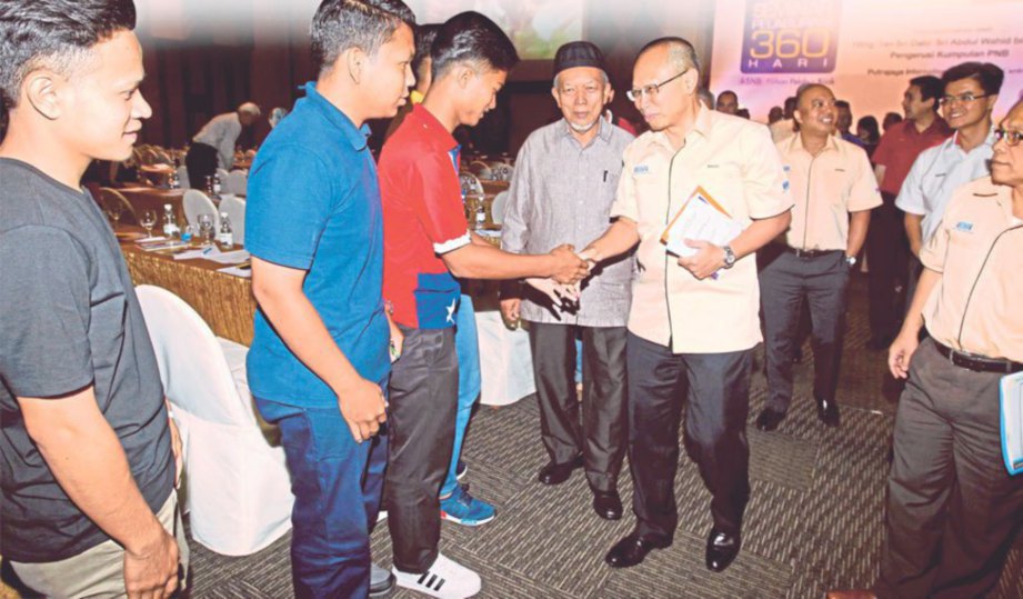 PENGERUSI Kumpulan PNB, Tan Sri Abdul Wahid Omar bersalaman dengan sebahagian peserta Seminar Pelaburan 360 Hari Mega.