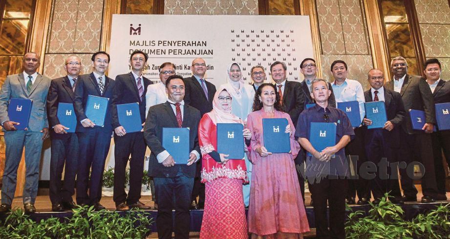 ZURAIDA (barisan belakang, tujuh dari kiri) bersama pemaju pada Majlis Penyerahan Dokumen Perjanjian antara PR1MA dan pemaju di Subang Jaya, hari ini. FOTO Hafiz Sohaimi.