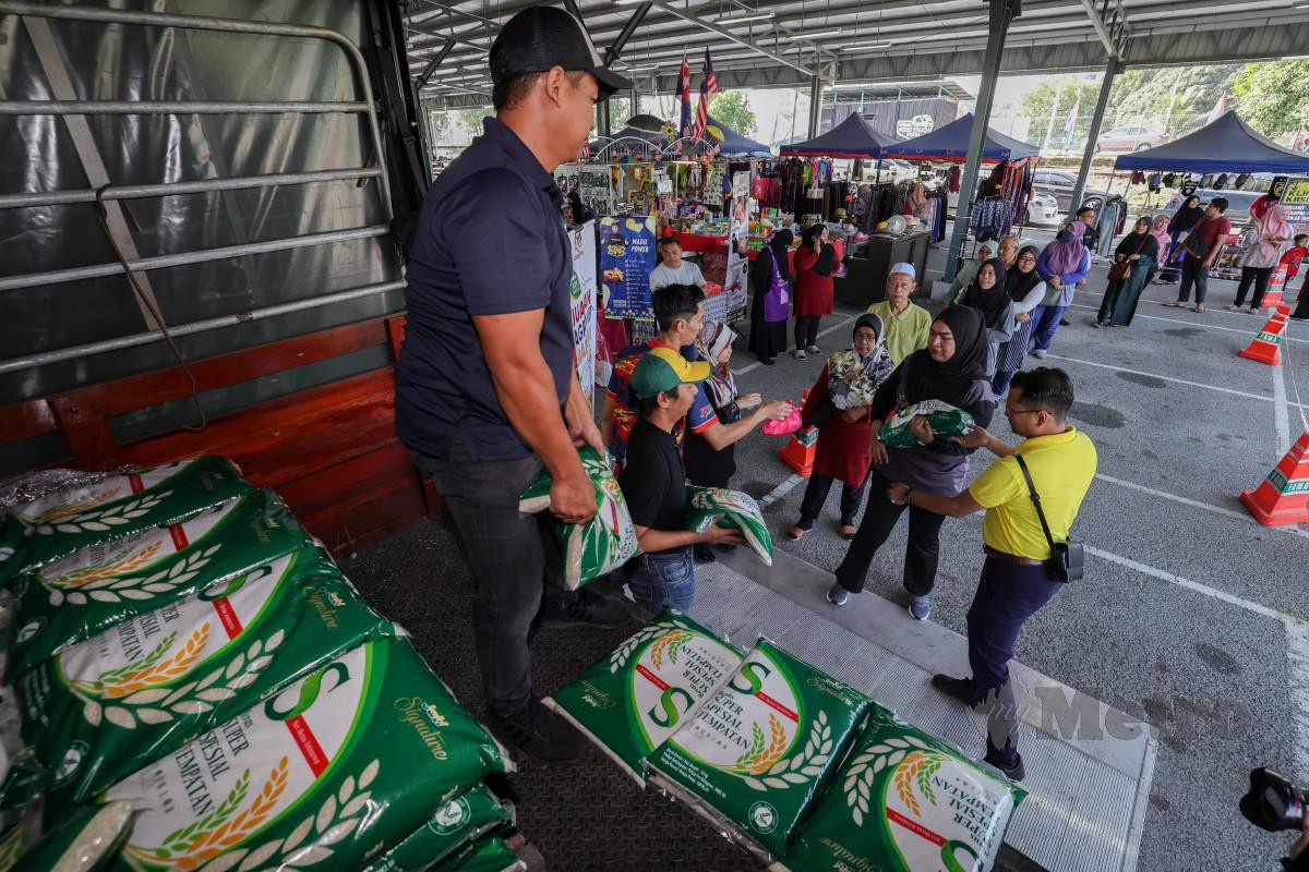 SEBAHAGIAN pengunjung tidak melepaskan peluang membeli bekalan beras tempatan pada Program Jualan Agro Madani di Pasar Tani Kekal, Jalan Datin Halimah, Larkin. FOTO Bernama 