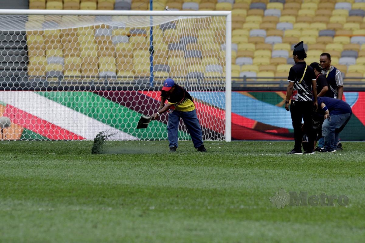PEKERJA am melakukan kerja membaik pulih rumput di padang sebelum perlawanan kelayakan Piala Asia 2023 antara Malaysia dan Bangladesh di Stadium Nasional, Bukit Jalil, Selasa lalu. FOTO AIZUDDIN SAAD