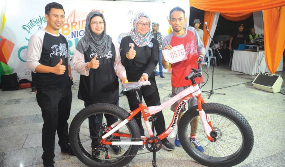 TENGKU AINA dan Nor Yahati menyampaikan basikal kepada peserta yang memenangi hadiah cabutan bertuah.