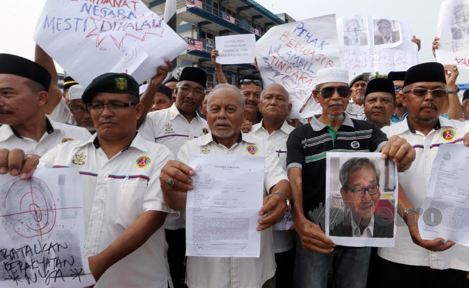 ABDULLAH (tengah) bersama sebahagian ahli PVATM Pahang menunjukkan salinan laporan polis berkaitan kenyataan ahli perniagaan memperlekehkan anggota tentera di IPD Kuantan. FOTO FARIZUL HAFIZ AWANG