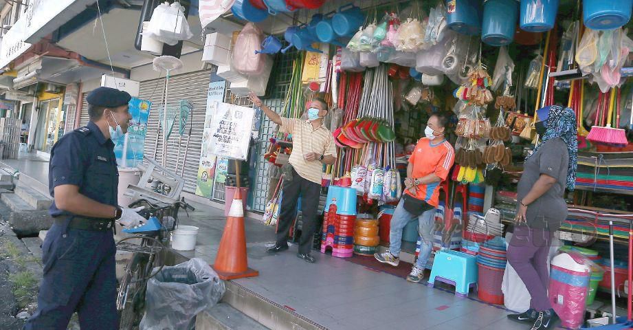 NIK Ezanne (kiri) melakukan tinjauan di kedai runcit berhampiran pasar Jalan Othman. FOTO Hairul Anuar Rahim