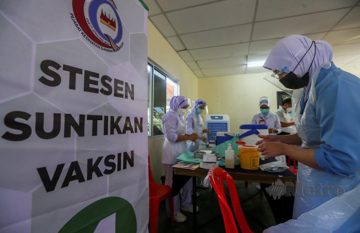 PETUGAS Petugas kesihatan membuat persediaan pemberian vaksin di PPV Bergerak di Kampung Orang Asli Tering, Johol. FOTO Azrul Edham Mohd Aminuddin