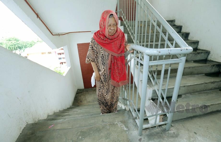 RAHMAH terpaksa menaiki tangga disebabkan lif rosak. FOTO SAIFULLIZAN TAMADI