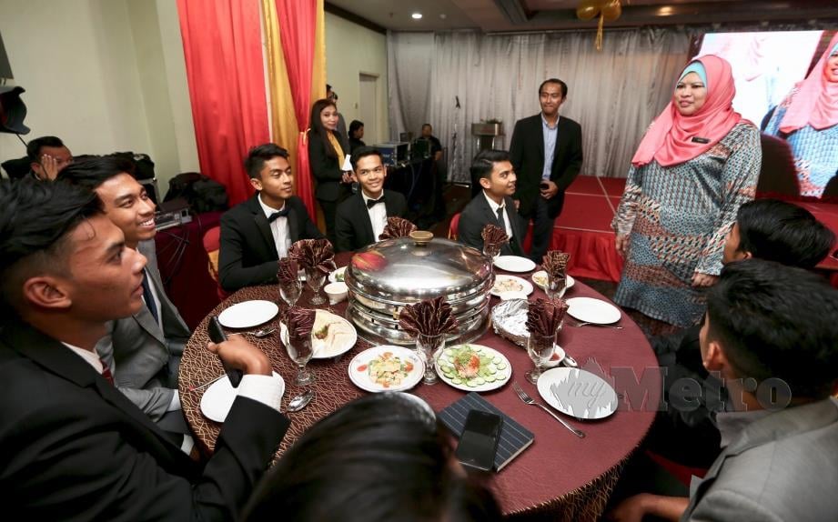 RINA (berdiri kanan) berbual dengan graduan cemerlang yang akan melanjutkan pengajian di luar negara pada majlis hi-tea di Kuala Lumpur, semalam. FOTO ZUNNUR AL SHAFIQ.