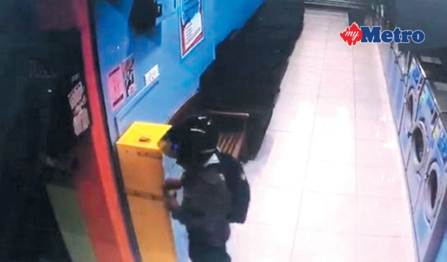 RAKAMAN CCTV menunjukkan suspek mengumpil mesin tukar duit syiling di kedai dobi layan diri 24 jam.